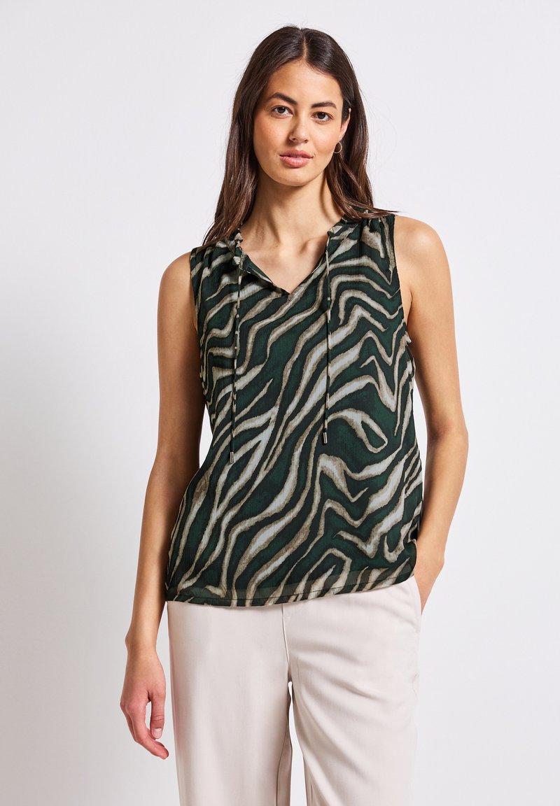 Top senza maniche in tessuto verde con stampa zebras in crema e marrone chiaro. Scollatura a V con lacci al colletto.