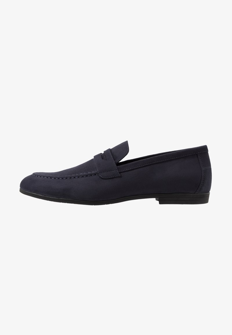 Mocassin bleu foncé pour homme, à enfiler, avec un petit talon, une couture style mocassin et une bride sur le dessus.