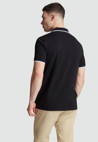 Zwarte polo met een effen ontwerp, voorzien van een klassieke kraag en blauwe strepenaccenten op de mouwen. Lichtgewicht, ademende stof.