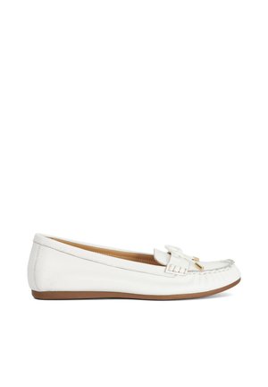 Witte leren platte loafer met gestikte naad, tassel detail en bruine zool, zijaanzicht op een witte achtergrond.