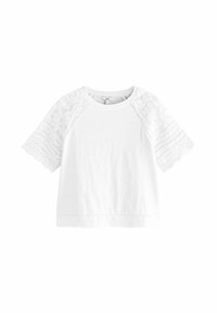 T-shirt bianco in cotone con maniche corte in pizzo intricato e bordi a scallop. Presenta un collo rotondo e un design a vestibilità rilassata.