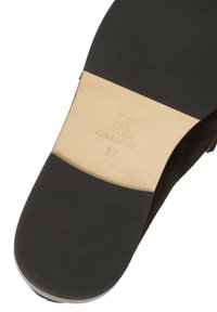Melnās ādas zoles ar gludu brūnu ādas paneļa daļu, uz kuras ir iespiests "KS REAL LEATHER" un izmērs "37".