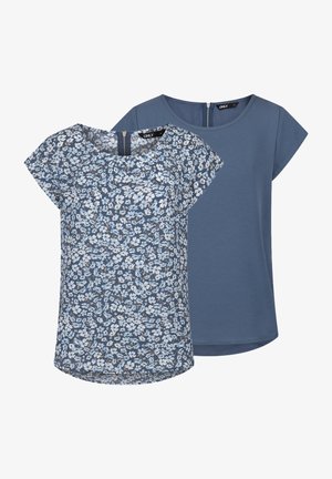 Floral print top in blue tones with short sleeves and rounded neckline, paired with a solid blue top featuring a subtle zip detail at the back.