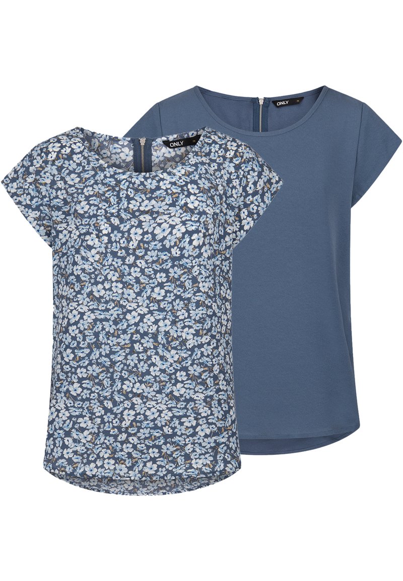 Top a stampa floreale in tonalità blu con maniche corte e scollatura rotonda, abbinato a un top blu a tinta unita con un sottile dettaglio con zip sulla schiena.
