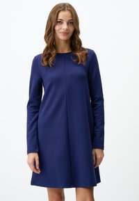 Vestito blu navy a maniche lunghe con scollatura rotonda, texture liscia e un corpino aderente che si allarga dolcemente fino all'orlo.