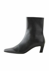 Bottine en cuir noir avec un bout pointu et un petit talon mince. Texture lisse, design minimaliste, sans fermetures ni motifs visibles.