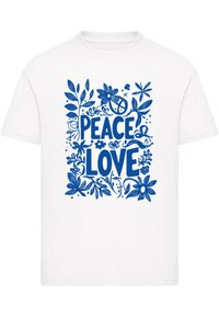 Hvid bomulds t-shirt med et blåt blomstermotiv, der har ordene "PEACE" og "LOVE" i fed, stiliseret typografi.