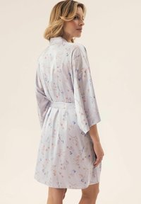 Kwiatowy kimono w jasnoszarym materiale z pastelowymi kwiatami, szerokimi rękawami i paskiem w talii, o miękkiej teksturze i gładkim wykończeniu.