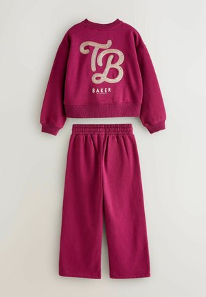 Růžová mikina a odpovídající kalhoty, zdobené velkým třpytivým logem "TB" a textem "BAKER", s vroubkovanými manžetami a elastickým pasem.