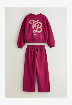 Rózsaszín pulóver és hozzá illő nadrág, nagy csillogó "TB" logóval és "BAKER" felirattal, bordázott mandzsettával és elasztikus derékrésszel.