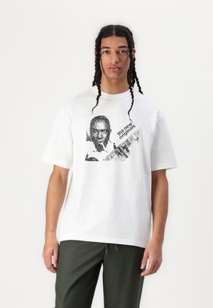 White cotton T-shirt featuring a black graphic print of a man with a guitar and text "the new originals." Short sleeves and relaxed fit.