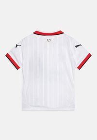 Maillot de football blanc avec des rayures verticales, accents de col rouge, manches courtes et logo Puma noir sur les manches. "125 ans" imprimé à l'arrière.