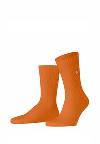 Orange gerippte Crew-Socken mit einer glatten Textur, die auf einer Seite ein kleines Logo und einen engen Sitz am Knöchel aufweisen.