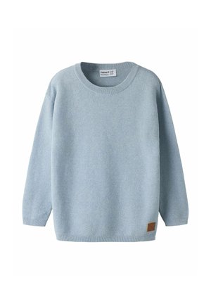 Pull bleu clair en maille à manches longues avec col rond et petit écusson marron près de l'ourlet inférieur.