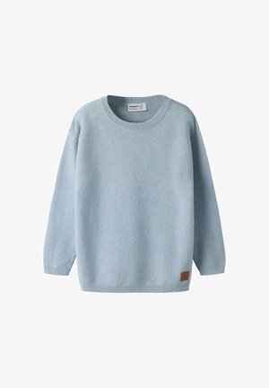 Pull bleu clair en maille à manches longues avec col rond et petit écusson marron près de l'ourlet inférieur.
