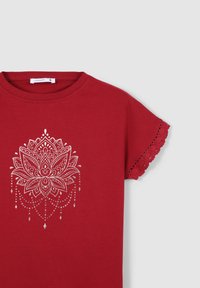 T-shirt di cotone rosso con grafica di un fiore di loto argentato, con dettagli in pizzo ondulato sulle maniche.
