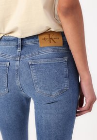 Jeans i ljusblå tvätt med en åtsittande design, som har två bakfickor, en märkestagg i läder och en mjuk yta.