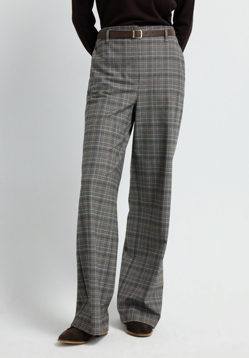 Grijze geruite broek met een rechtvallende pasvorm, voorzien van een bruine riem met een vierkante gesp en subtiele textuur in de stof.