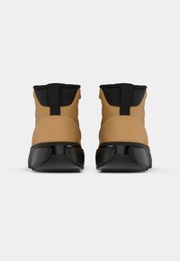 Calzature beige e nere con design high-top, caratterizzate da una tomaia liscia, un tallone texturizzato e una suola nera prominente con accenti curvi.