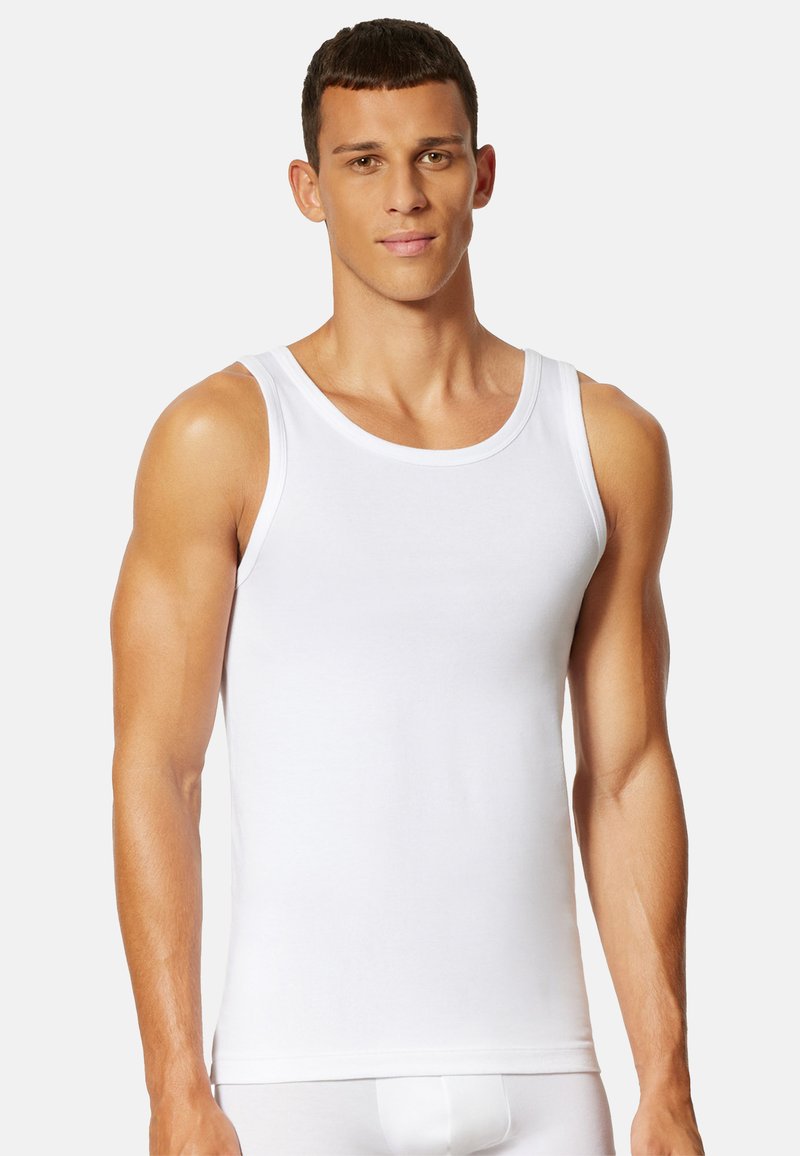 Hvid bomulds tanktop med brede stropper, rund udskæring og en glat overflade. Designet til en tætsiddende silhuet og komfort.