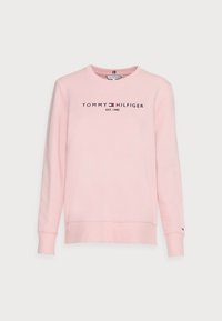 Różowa bawełniana bluza z okrągłym dekoltem, ściągaczami przy rękawach i u dołu oraz logo "TOMMY HILFIGER EST. 1985" w ciemnym granacie z przodu.