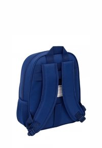 Zaino blu navy con spallacci imbottiti regolabili, tessuto morbido, tasca laterale in rete e forma rettangolare. Include un'etichetta sul retro.
