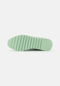 Sola de sapatilha em verde menta claro, com uma textura estriada para aderência. Forma elegante com ligeira curvatura na ponta e no calcanhar.