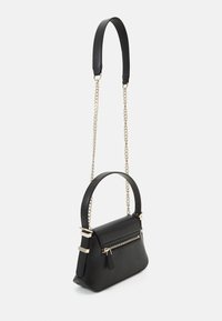 Bolso de mano de cuero negro con forma estructurada, cadena y tirantes en tono dorado, con un bolsillo frontal con cremallera y textura suave.