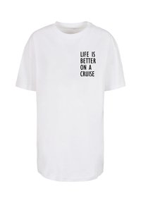 Weißes Baumwoll-T-Shirt mit lockerer Passform. Auf der Vorderseite steht in schwarzer Schrift "DAS LEBEN IST BESSER AUF EINER KREUZFAHRT". Kurze Ärmel, Rundhalsausschnitt.