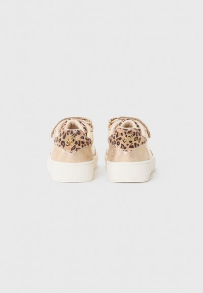 Zapatillas de leopardo con detalles dorados, una parte superior texturizada en dorado y una suela blanca lisa, con cordones y un detalle del logo en el talón.