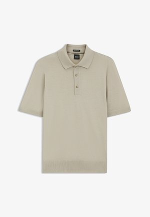 Beige lyhythihainen poolopaita, jossa on resorit hihansuissa ja helmassa, kaksi beigeä nappia ja musta "BOSS"-merkki kauluksen sisäpuolella.