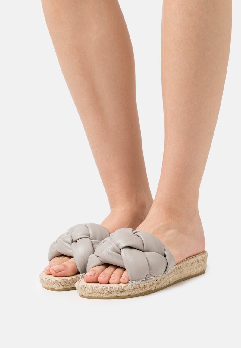 Szare klapki z plecionym paskiem, z cholewką z teksturowanej skóry i plecioną podeszwą w stylu espadryli. Otwarty przód odsłania naturalne palce.