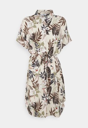 Abito camicia floreale color crema con motivi di foglie marroni e verdi, maniche corte, chiusura frontale con bottoni e vita con coulisse per una vestibilità regolabile.