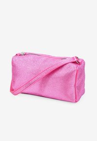 Bolso de mano rosa con cierre de cremallera, cubierto de pequeños clavos brillantes, con una fina correa para el hombro y forma rectangular.