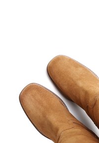 Brown suede ankle boots with a rounded toe, smooth texture, and visible stitching along the sole. Simple design, no embellishments.