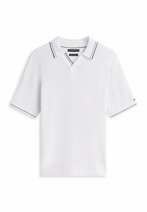 Polo blanco de manga corta con tela texturizada, ribete negro en el cuello y las mangas, y un pequeño logo en la manga izquierda.