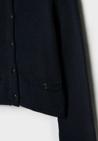 Navy knitted cardigan with a textured pattern, featuring five metallic buttons, two front pockets, and ribbed cuffs.