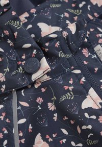 Marineblauer Stoff mit einem floralen Muster, das rosa Blumen und weiße Schmetterlinge zeigt. Enthält einen grauen Akzent und ein rundes schwarzes Knopfdetail.