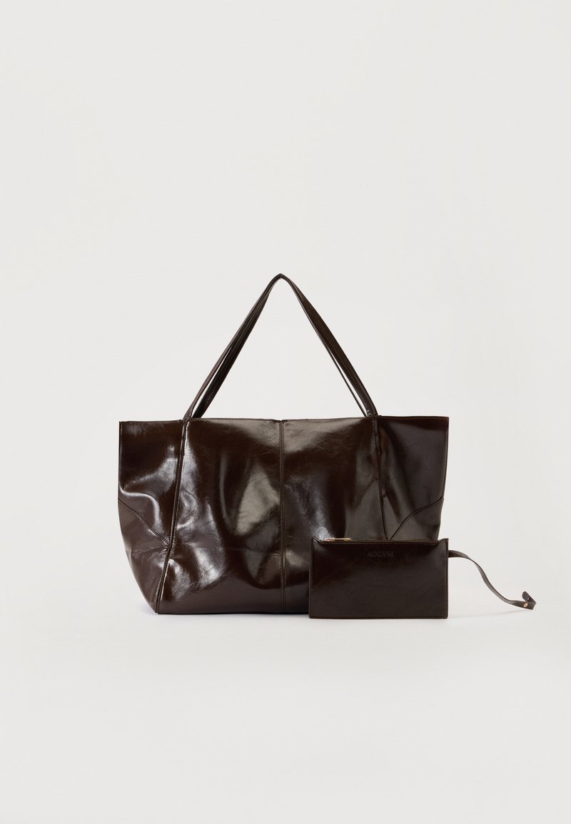 Grand sac cabas en cuir marron foncé brillant avec deux bretelles d'épaule et une petite pochette zippée assortie avec une lanière pour le poignet.