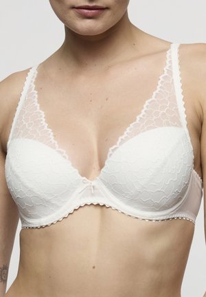 Witte kanten beha met een geschulpte rand, voorgevormde cups en een klein strikje in het midden. Heeft doorschijnende kanten panelen aan de zijkanten.