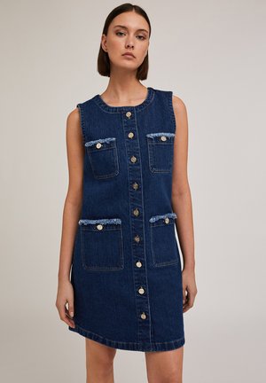 Robe sans manches en denim bleu foncé avec un col rond, fermeture à boutons sur le devant, deux poches poitrine et des accents de poches effilochés.