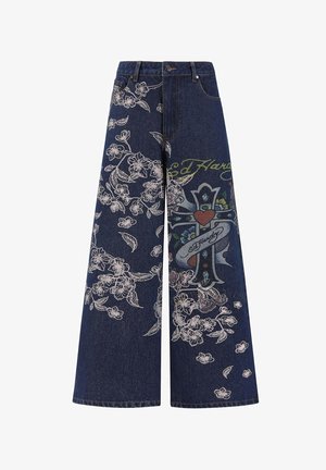 Weite Denim-Jeans aus dunkelblauem Stoff mit weißer Blumenstickerei und einem zentralen bunten Grafikdesign mit einem Kreuz und einem Herzen.