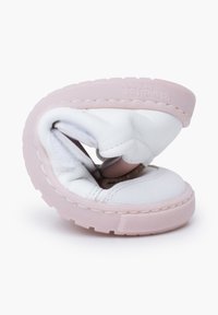Scarpa in pelle bianca con suola in gomma rosa, caratterizzata da un design flessibile e texture morbida, visibilmente piegata in una forma unica.
