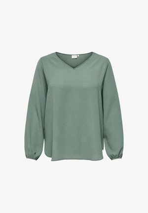 Haut long à manches vert en tissu texturé, avec un décolleté en V et des poignets froncés, présentant une coupe décontractée et des détails subtils dans le matériau.