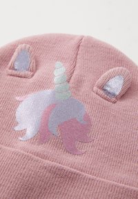 Bonnet en tricot rose avec un design de licorne, une corne et des oreilles scintillantes, tissu texturé et accents pailletés sur le motif.