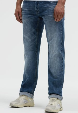 Jeans aus Denim in mittelblau, mit geradem Bein, verblasstem Finish, im Five-Pocket-Stil, kombiniert mit hellgrauen Sneakers mit Logo-Detail.