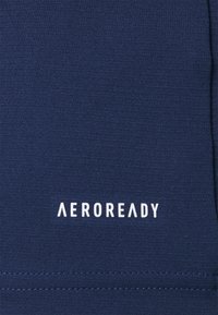 Tumma laivastonsininen urheiluvaatekangas, jossa on sileä pinta ja jossa on alareunassa valkoinen "AEROREADY"-logo. Yksinkertainen muotoilu ilman kuvioita tai koristeita.