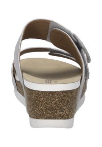 Witte sandaal met kurken sleehak, suede banden en een verstelbare sluiting. Beschikt over een glad voetbed en een gestructureerde buitenzool.