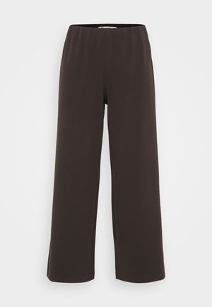 Tummanruskeat väljät housut, jotka on valmistettu pehmeästä ja joustavasta kankaasta. Niissä on joustava vyötärö ja ei näkyviä kiinnityksiä. Housuilla on sileä pinta.