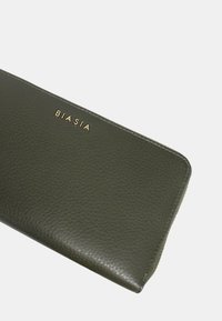 Portafoglio in pelle verde oliva con superficie texture, chiusura con zip e logo "BIASIA" in tonalità oro. Forma rettangolare con angoli arrotondati.